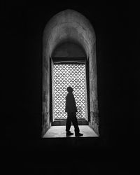 Rear view of silhouette woman standing against wall