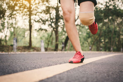 Low section of woman running on road