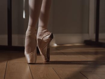 Low section of woman sitting on hardwood floor