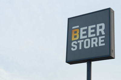 Low angle view of road sign against sky