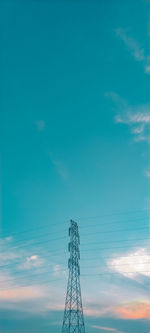 Low angle view of electricity pylon against blue sky