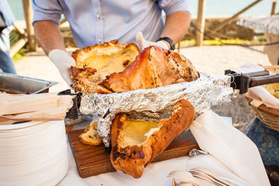 Midsection of man holding roasted pork