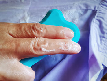 Close-up of woman hand on purple wall