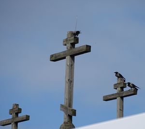 Low angle view of cross sign against clear blue sky