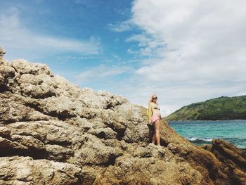 Mid adult woman standing on rocky shore