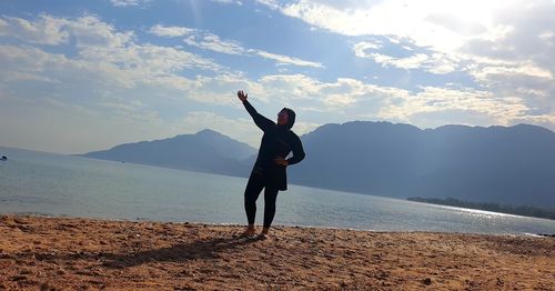 Full length of man standing on beach against sky