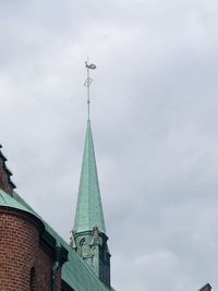 Low angle view of clock tower amidst buildings against sky