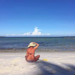 Rear view of people sitting on beach