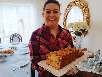 Portrait of beautiful woman serving fruitcake