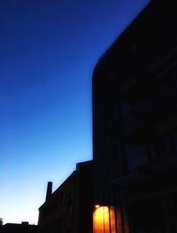 Low angle view of illuminated building against blue sky