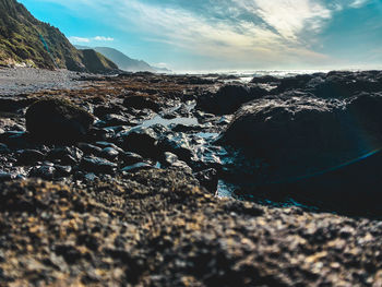 Close-up of rocks on shore against sky