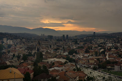 High angle view of cityscape against cloudy sky during sunset