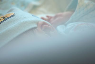 Close-up of baby lying on bed