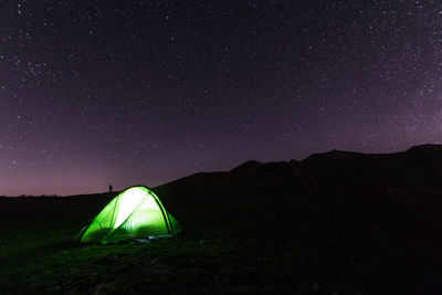 Scenic view of illuminated tent against sky at night