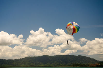 Low angle view of person paragliding against sky