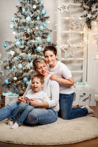 Mommy with kids are sitting on the floor in a room decorated with garlands