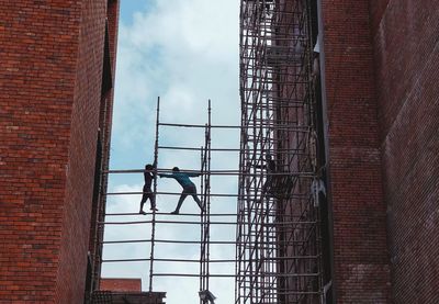 Low angle view of people on scaffolding