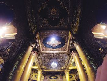 Low angle view of illuminated chandelier hanging in building