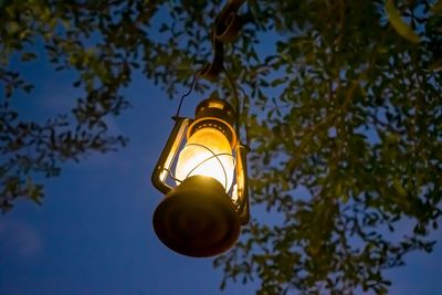 Low angle view of illuminated light bulb against sky