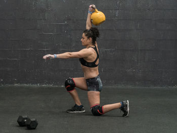 Woman exercising with dumbbell in the gym