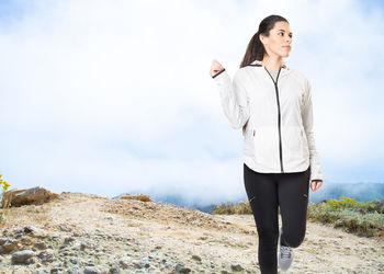 Young woman on mountain against sky