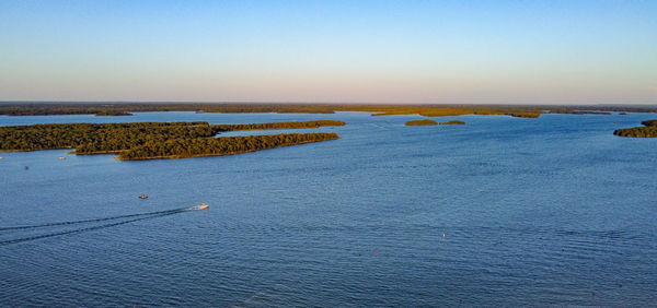 Boats cruising lake murray close to sunset.