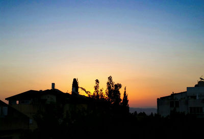 Silhouette built structure against clear sky at sunset