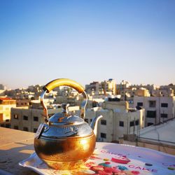 Close-up of drink on table against buildings in city