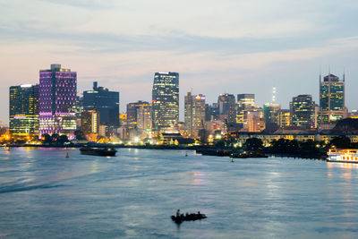 Illuminated buildings in city against sky