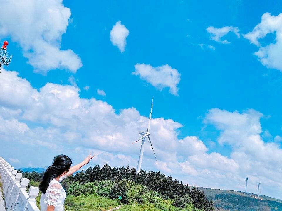 WOMAN WITH UMBRELLA AGAINST BLUE SKY