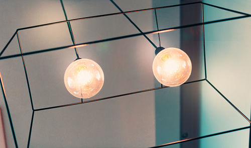 Low angle view of light bulb hanging on ceiling