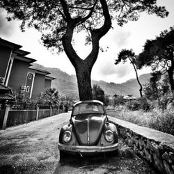 Car on road by building against sky