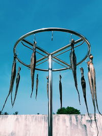 Low angle view of hanging against clear blue sky