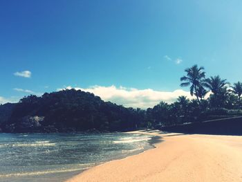 Scenic view of beach against blue sky