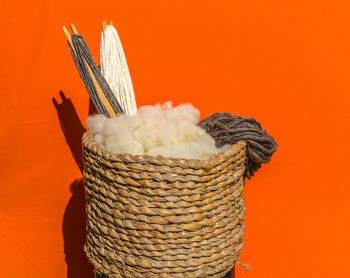 Close-up of wicker basket against orange wall