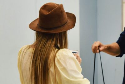 Rear view of woman holding hat