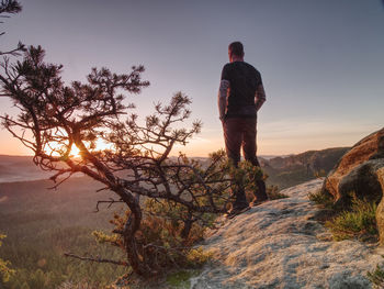 Tall man in sports clothes enjoy morning view into pure nature landscape. guy clear his soul.