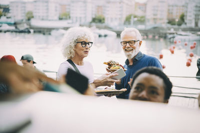 Smiling male and female customers enjoying indian food in city