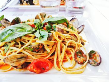 Close-up of noodles with clams in white plate on table