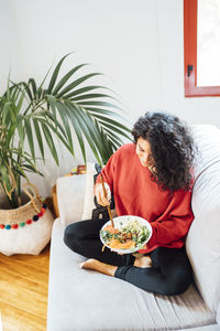 Brunette woman eating a healthy green salad.