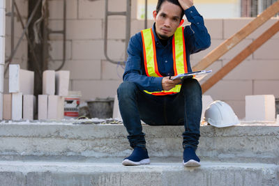 Full length of young man sitting on staircase