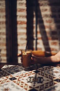 Hand holding coffee cup on table