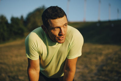 Male athlete looking away during sunset