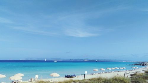 Scenic view of beach against blue sky