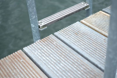 High angle view of plank on metallic poles over boardwalk against sea