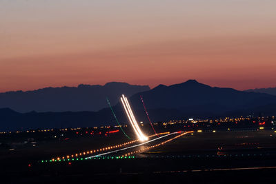 Illuminated bridge against sky at night