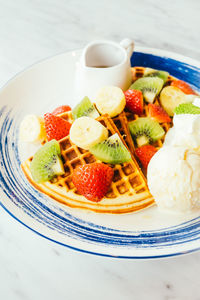 Close-up of fruits and waffles in plate