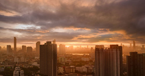 Cityscape with skyscraper building and morning sunlight. riverfront city with orange sunrise. 