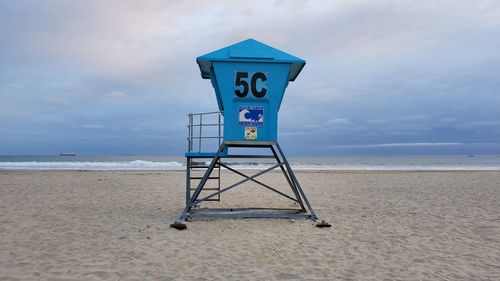 Lifeguard hut on beach against sky