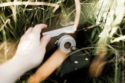 Woman is holding an anlog camera.